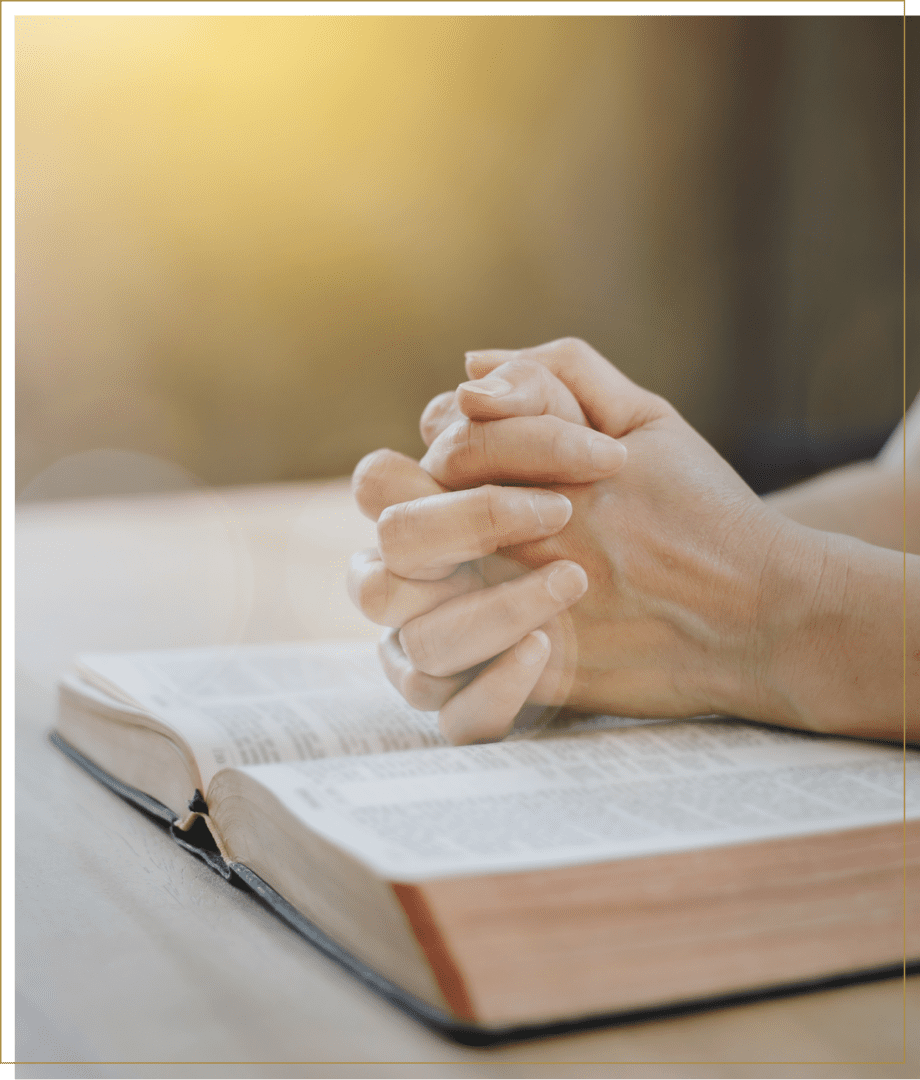 Prayer hands on a Bible