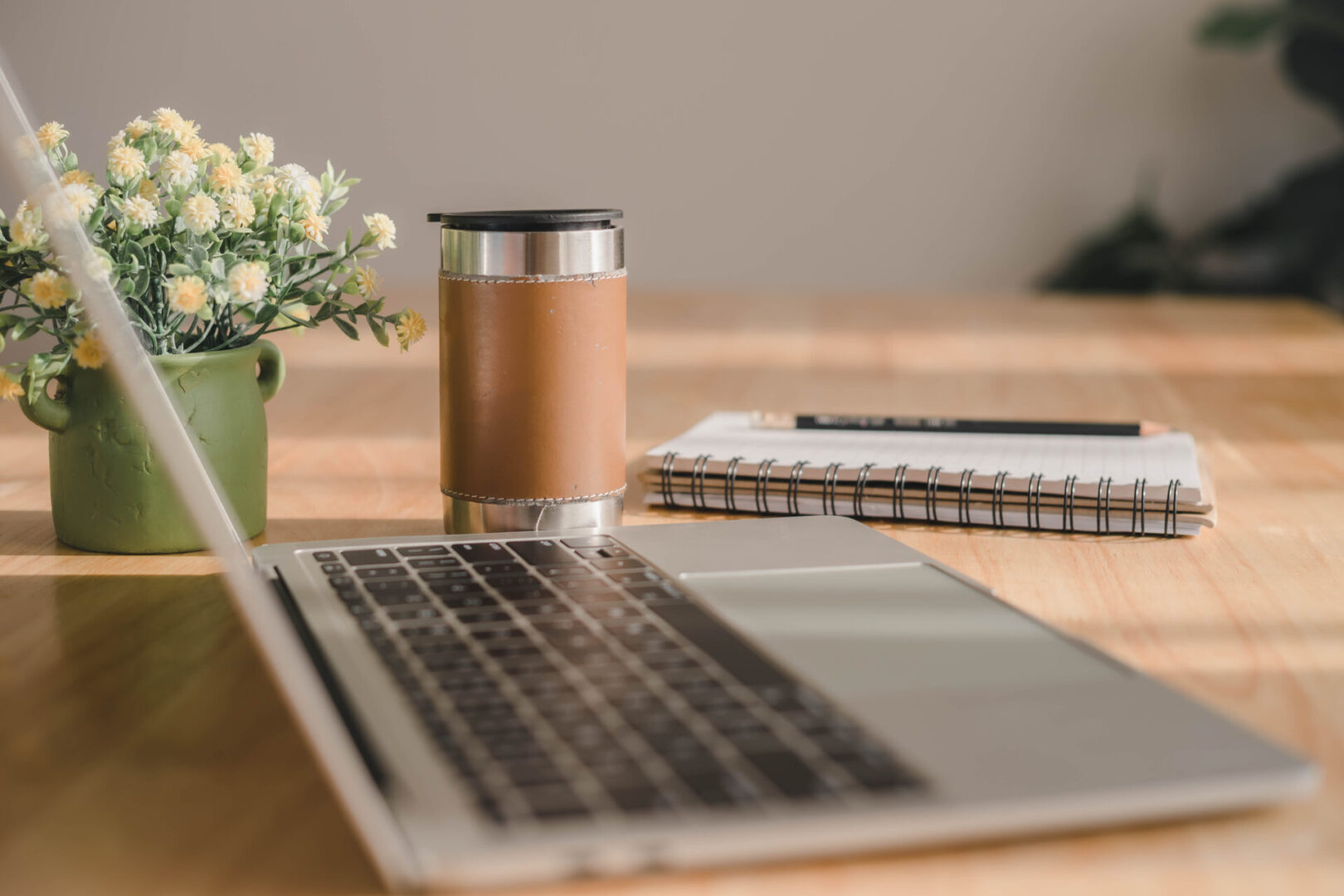 Workspace with flowers and laptop