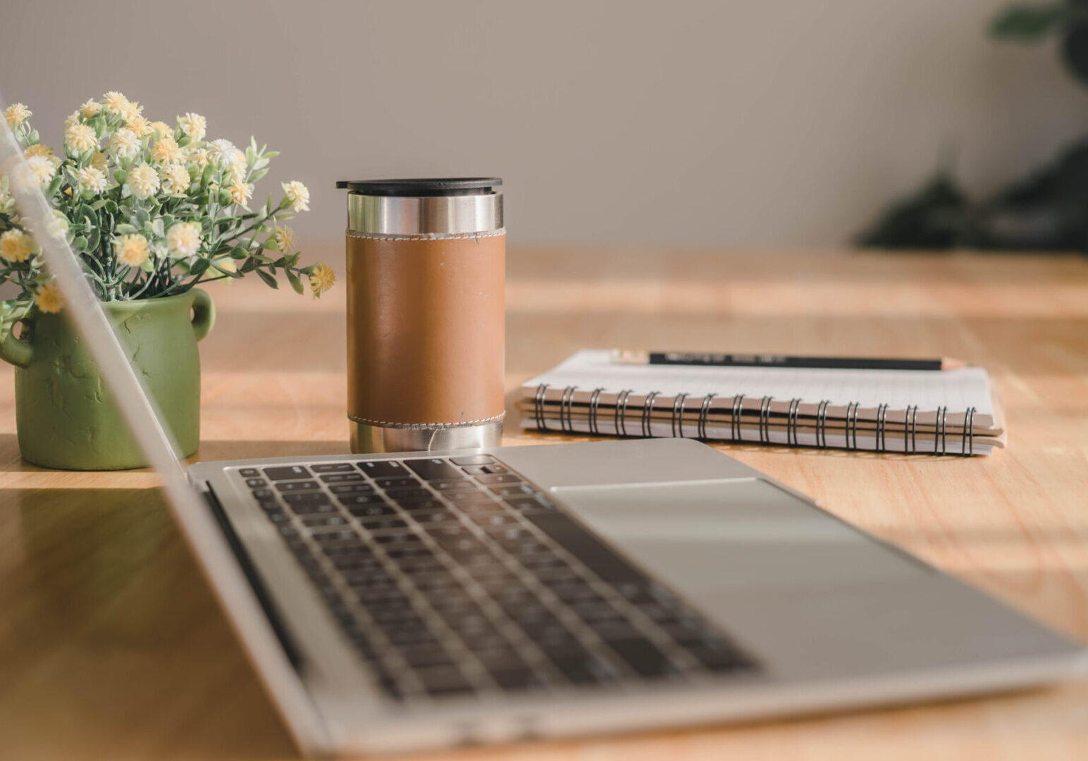 Workspace with flowers and laptop